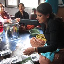 A group of women who learnt business skills at the library fill lunch boxes which the sell, as a small business.