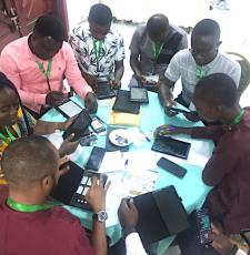 Group of public librarians with tablets, sitting around a table, during a workshop.