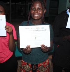 Three young ICT graduates from Kawempe Youth Centre and Community Library show their certificates of achievement.