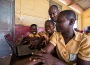 School children using a laptop.