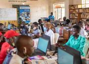 Young people and women learning ICT skills in a library in Uganda.