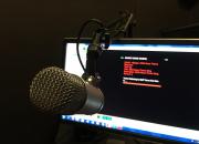 Image of a microphone with computer screen.
