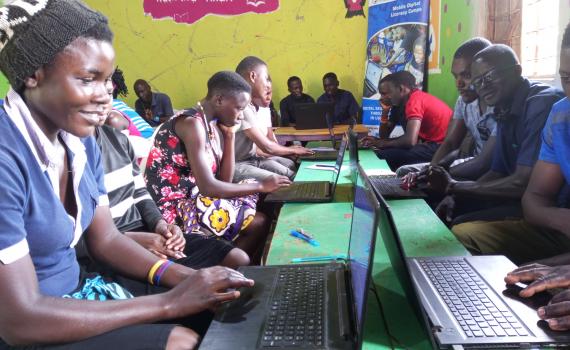 Women and youth undergoing computer training in Zigoti Community Library, Uganda.