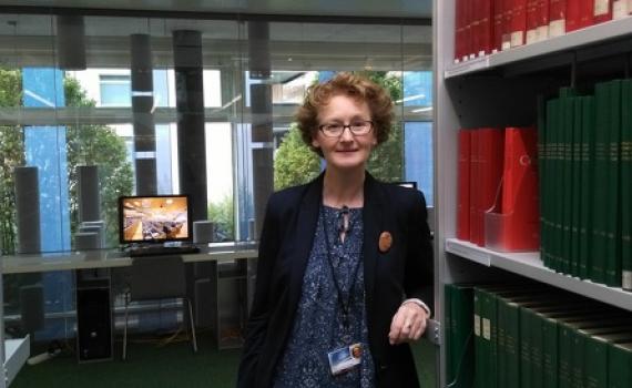 Teresa Hackett next to a bookshelf in the WIPO library.