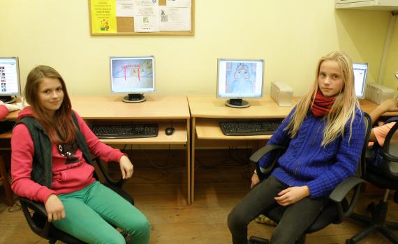 Two girls with their computers, showing how they make animated films. 