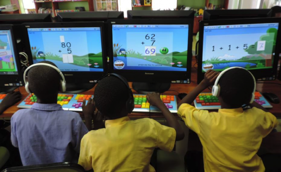 Three children using computers with maths software to practice their maths.