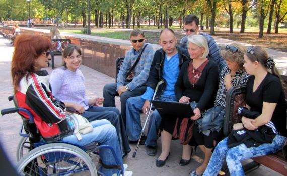 Group of trainees, some in wheelchairs, in the park.