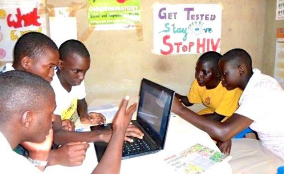 Teenagers using laptops to research the internet for health information in their library.